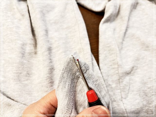 ズボンの裾口にゴムを入れるためにリッパ―でミシン糸を切る